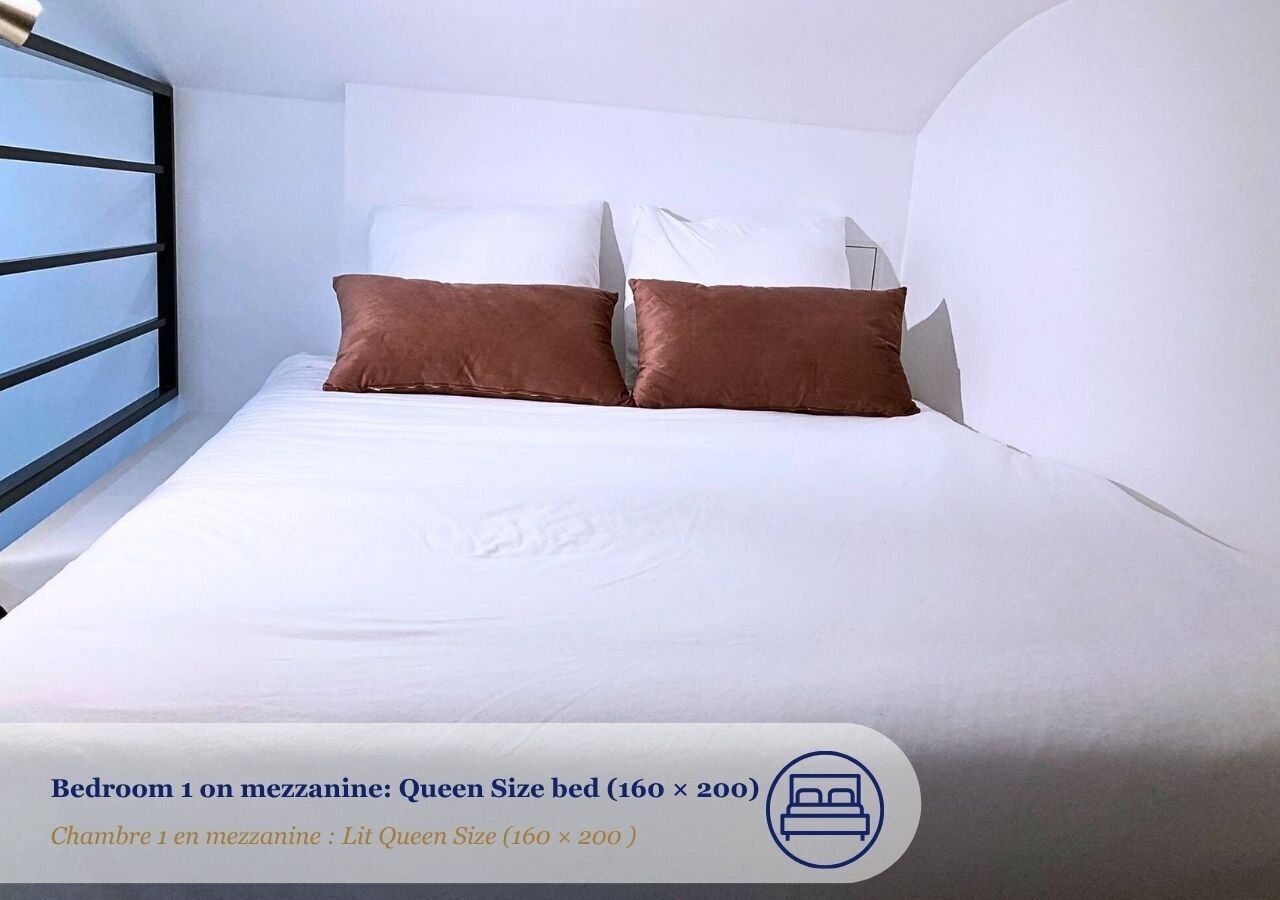 Ein Bett der Größe Queen mit weißer Bettwäsche und zwei braunen Kissen in einem Schlafzimmer.