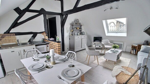 Una cocina moderna con comedor, que presenta una mesa blanca para cuatro personas, un horno empotrado y un mueble de cocina gris.