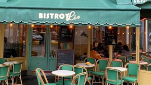 Ein Bistro mit Außenbereich, einer Kreidetafel und einem türkisblauen Markisen