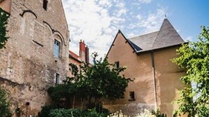 Ein historisches Gebäude mit einem markanten Turm und angrenzenden Gebäuden.
