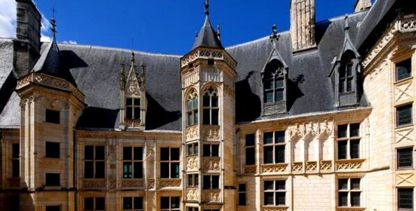 A historic building with a central tower, multiple windows, and ornate architectural details.