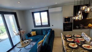 Un espace de vie moderne comprenant un canapé, une table à manger et un coin cuisine.