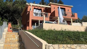 Un bâtiment à deux étages avec un escalier en pierre menant à un balcon.