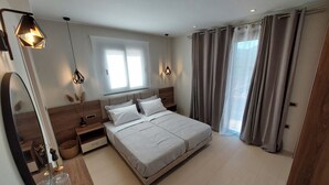 Une chambre moderne avec un grand lit, des tables de chevet, un miroir et une fenêtre avec des rideaux.