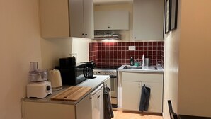 A compact kitchen with a microwave, toaster, and small refrigerator.