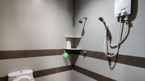 Un baño pequeño con inodoro, lavabo y ducha.