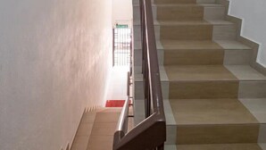Una escalera con barandilla de madera que lleva a una puerta al final.