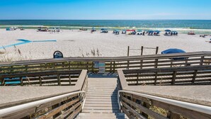 A wooden boardwalk leading to a beach with umbrellas and beach chairs. - FREE Golf Cart | New home located on resort style pool | Massive Kitchen/Private Balconies/Sleeps 12 (Santa Rosa Beach)