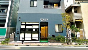A modern hotel building with multiple balconies and a prominent entrance. - KYU KYU HOTEL (Tokyo)
