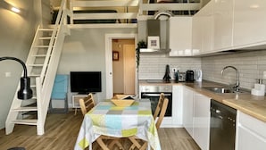 Eine kompakte Küche mit Essbereich, einer Treppe und einem Fernseher.