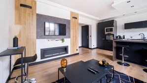Uma cozinha moderna com televisão de tela plana, micro-ondas e um espaço de bar.