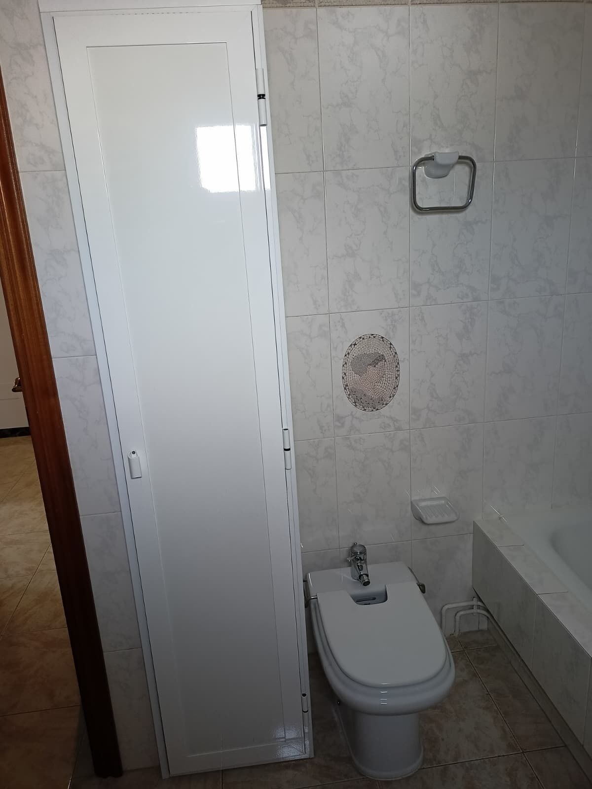 Kylpyhuone, jossa on wc, bidee, pyyhekoukku ja kylpyamme.