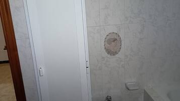 Kylpyhuone, jossa on wc, bidee, pyyhekoukku ja kylpyamme.