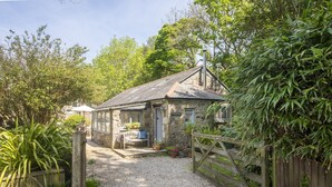 A stone cottage with a gravel driveway and a wooden gate. - Rosehendra - A beautifully refurbished pet-friendly barn conversion with two bedrooms, a log burner (Rosevidney)