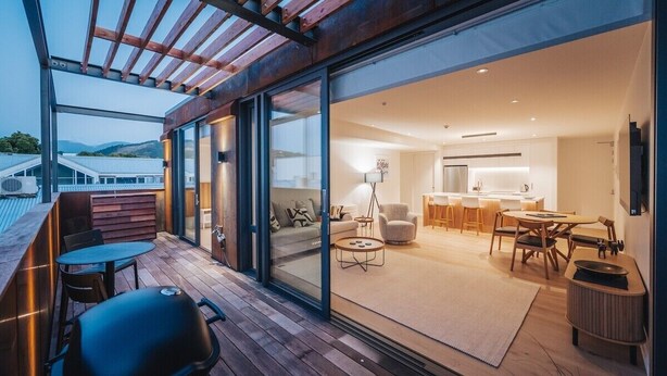 Ein modernes Interieur mit Essbereich, Küche und einem Balkon mit Grill.