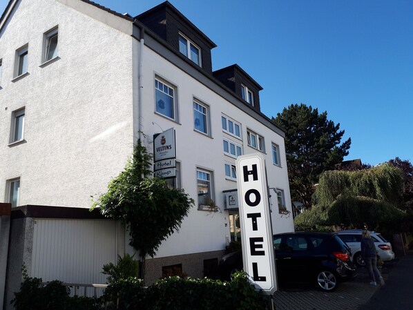 Un bâtiment d’hôtel avec une enseigne indiquant « HÔTEL » et « VELTINS Hotel Kamp ».