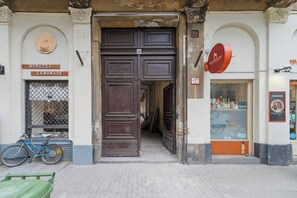A building with a large wooden door, a bicycle outside, and signs for 'Boba Tea' and 'Lemonade'.