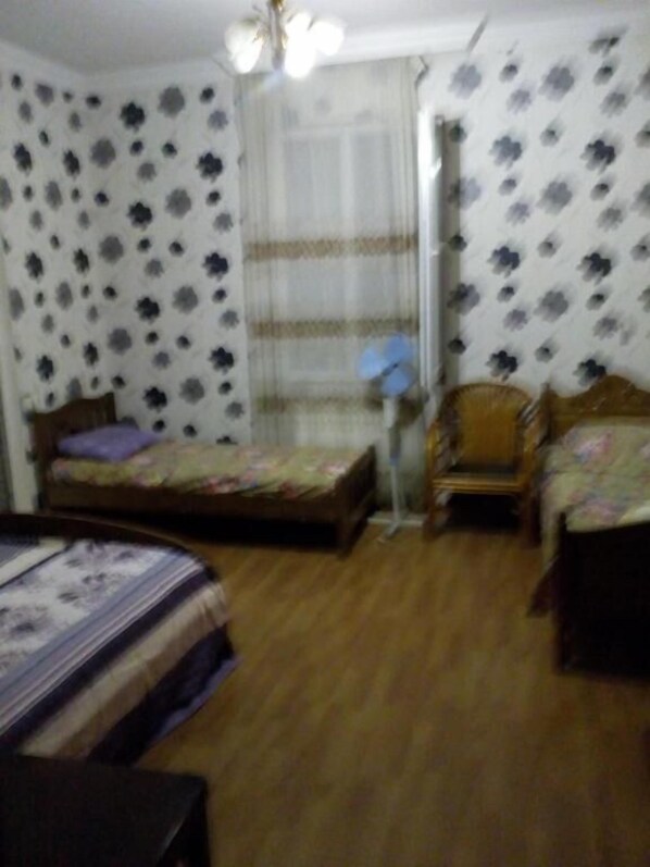A bedroom with a bed, a chair, and a small table. - Mini Hotel on Guramishvili 22 (Kobuleti)