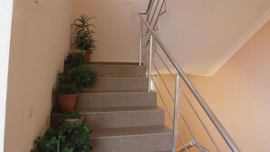 Un escalier avec des rampes en métal et des plantes en pot sur les marches.