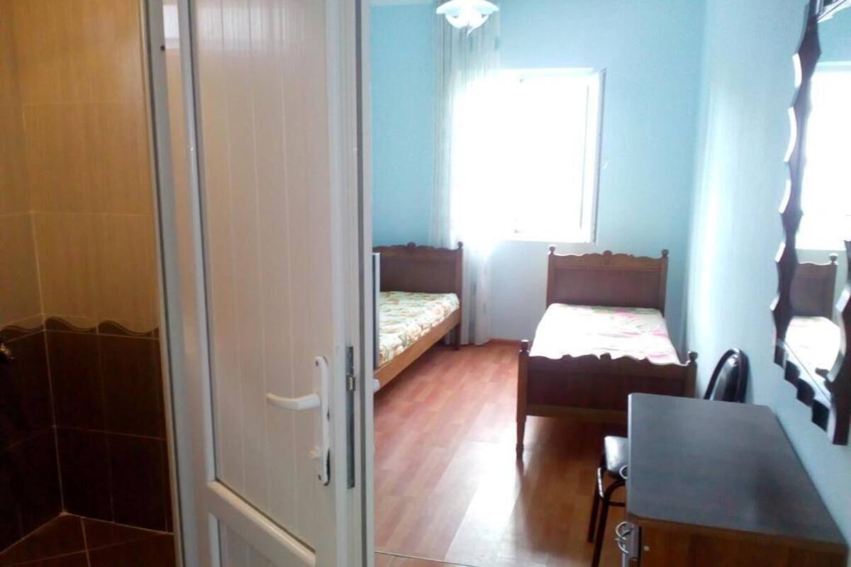 Un dormitorio con una cama de madera, un escritorio y una silla.