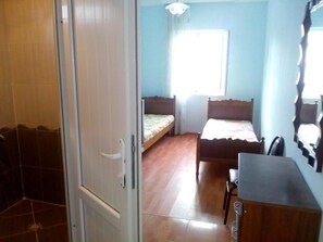 Un dormitorio con una cama de madera, un escritorio y una silla.
