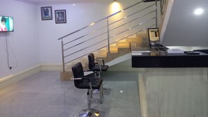 A modern interior with a staircase, a reception desk, and a TV mounted on the wall. - FMMM1 (Agbor)