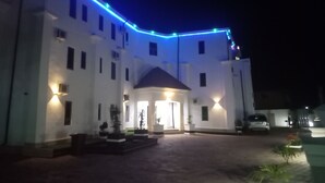 A building with a white facade, multiple windows, and a central entrance with a roofed porch. - FMMM1 (Agbor)
