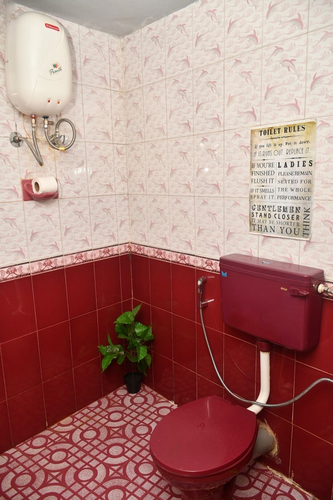 A bathroom with a toilet, a water heater, and a toilet paper holder.