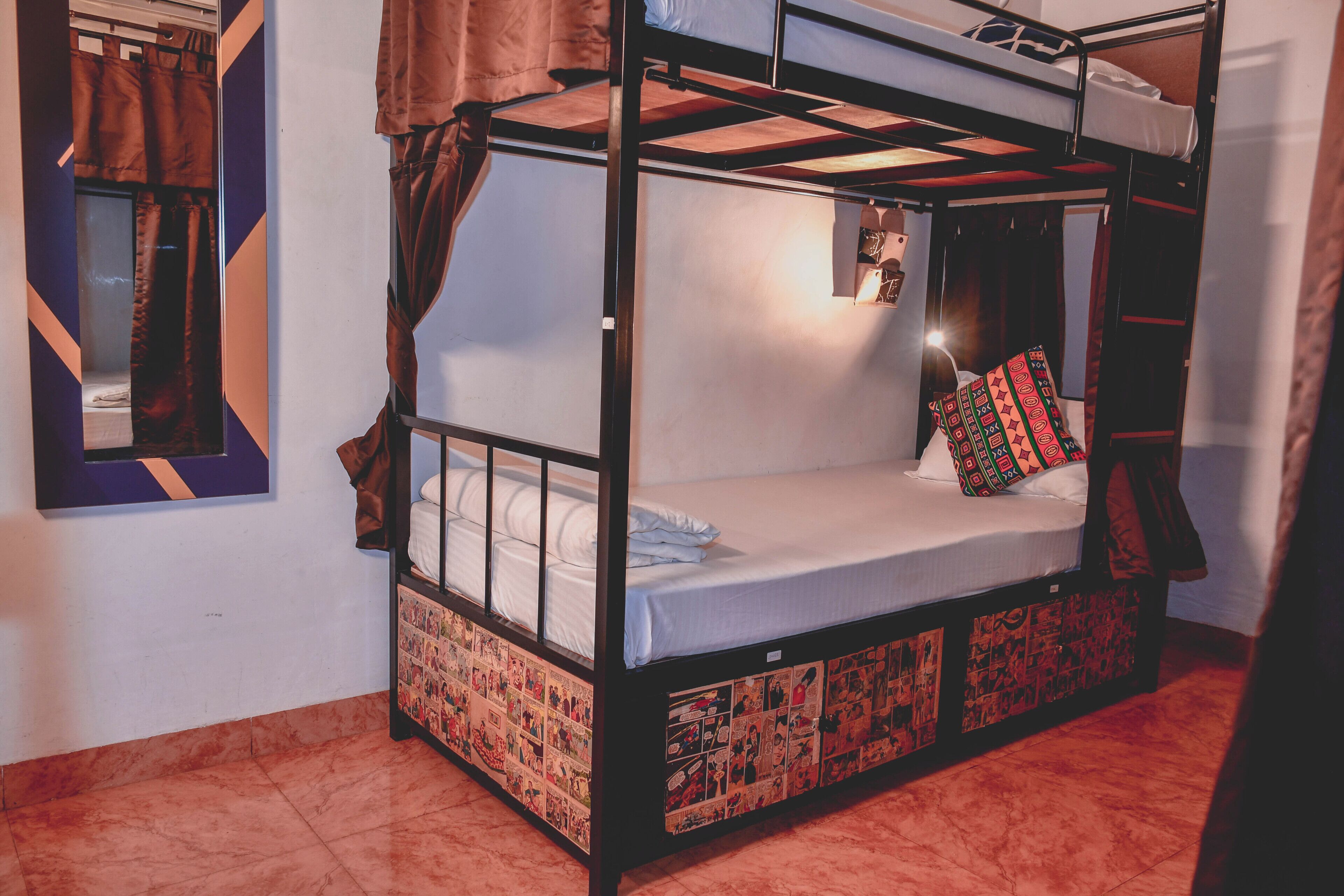 A bunk bed with a lower bunk, a small bedside table, and a wall-mounted shelf.
