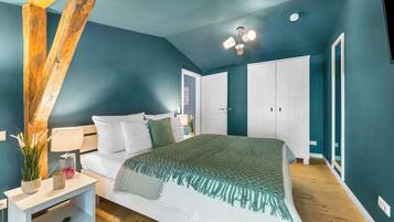 Una camera da letto con un letto, un comodino, una lampada e un'ampia finestra.