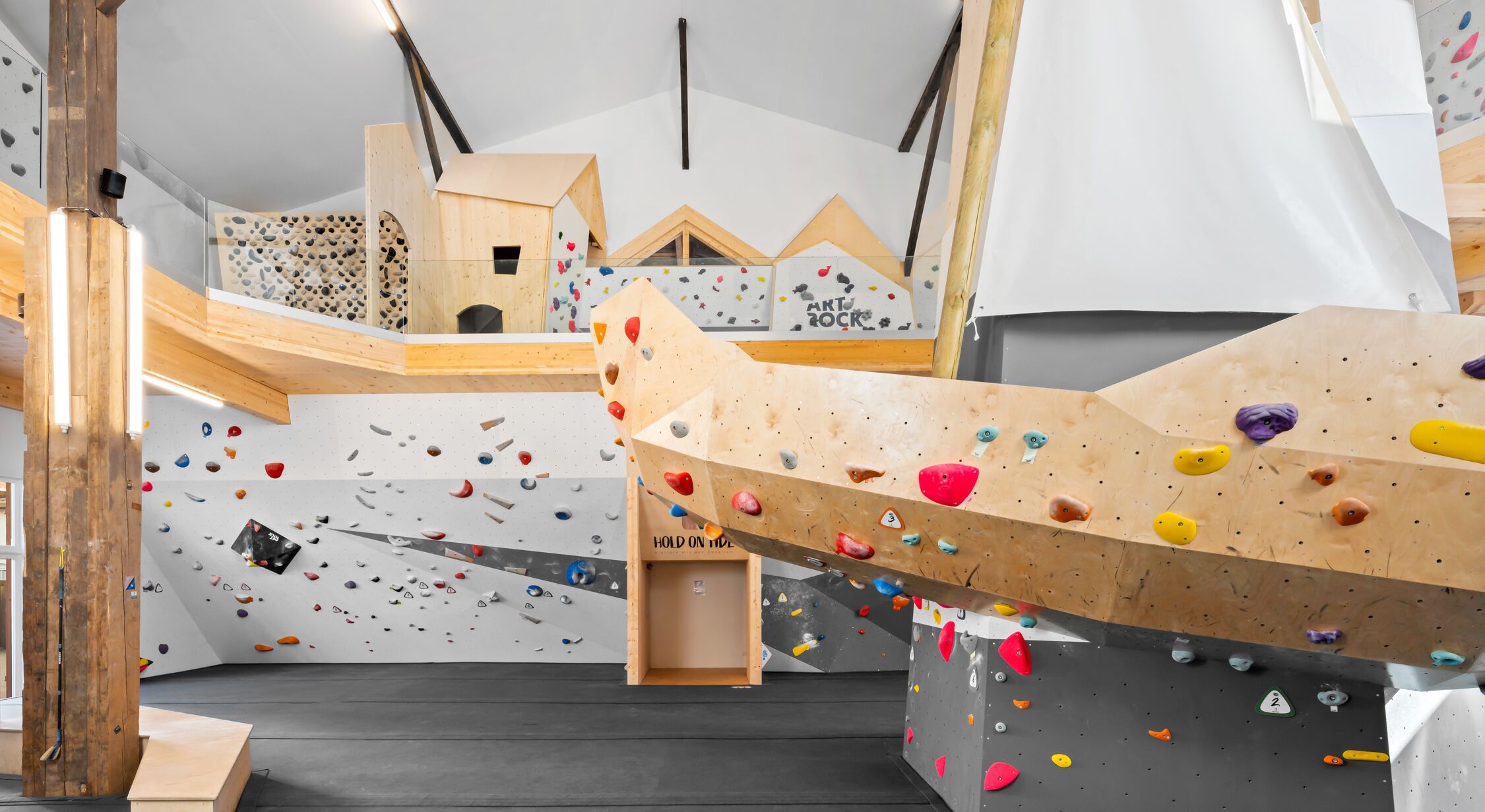 Ein Kletterzentrum mit verschiedenen Kletterwänden und Holzkonstruktionen.