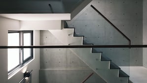 A modern staircase with glass railings and metal handrails, leading to different levels of a building. - Guangfa Hotel (Tainan)