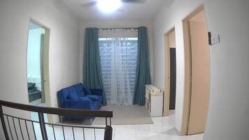 A hallway with a blue sofa, a small table, and a door.