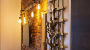 A brick wall with a mounted mirror and hanging light fixtures. - B&B Plitvice Queen (Plitvicka Jezera)