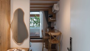 A modern interior with a wooden dining table, chairs, a mirror, and a built-in bench. - Zeus Living Central Hotel (Ho Chi Minh City)