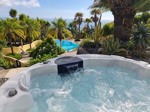 A hot tub surrounded by tropical plants and a pool, with a clear view of the ocean in the background. - Don Miguel La Palma - Private paradise for 9-12 persons (El Paso)