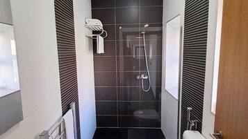 A compact bathroom with a shower, toilet, and sink.