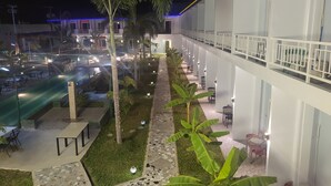 A hotel with a pool, outdoor seating, and a covered walkway. - Blue Hotel & Resort (Porac)