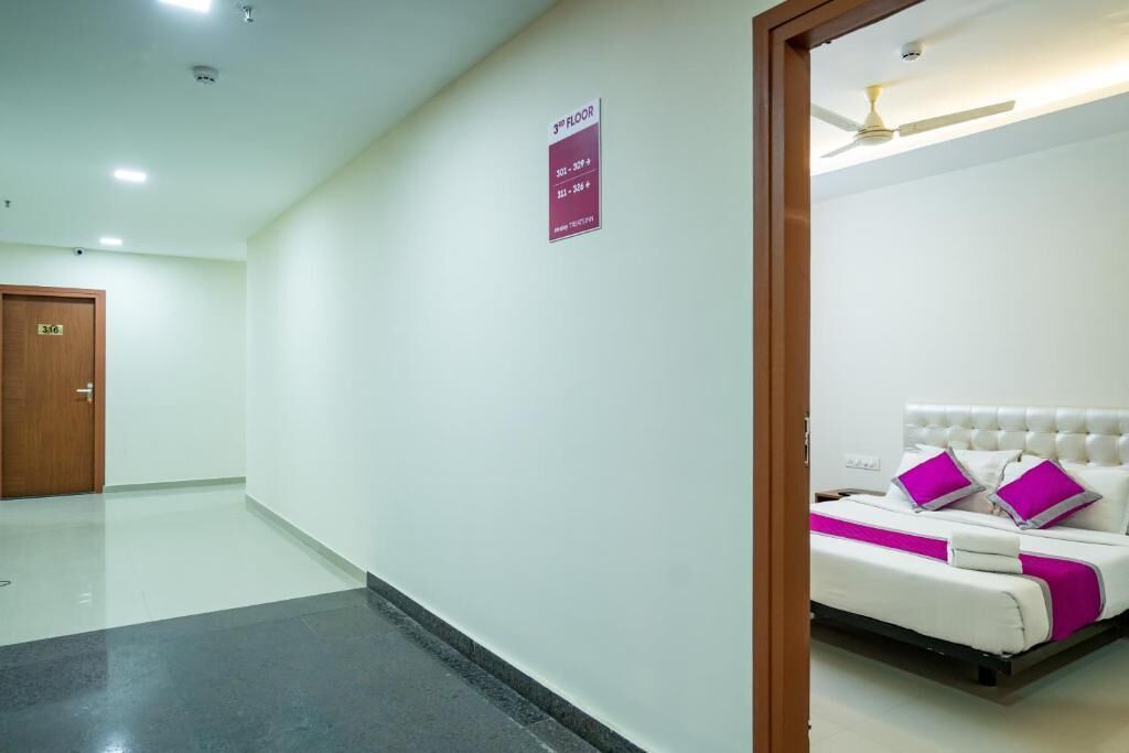 Quarto de hotel com cama, ventoinha no teto e placa indicando o 3º andar.
