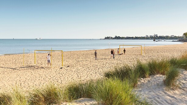 A beach with a volleyball net and people playing. - Charming House with Garden, Close to Beaches & Guérande, Free WiFi (Assérac)
