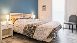 A bedroom with a bed, nightstands, a chair, and a window. - Charming House with Garden, Close to Beaches & Guérande, Free WiFi (Assérac)