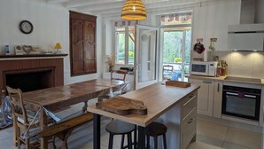 A kitchen with a wooden island, a microwave, and a stove. - Rustic old mill with garden, WIFI and parking, pets allowed (Saint-Mary)
