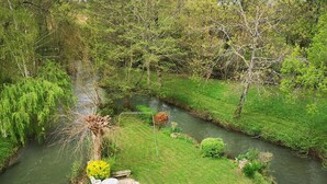 A river with a stone path, a small table, and chairs, surrounded by greenery and trees. - Rustic old mill with garden, WIFI and parking, pets allowed (Saint-Mary)