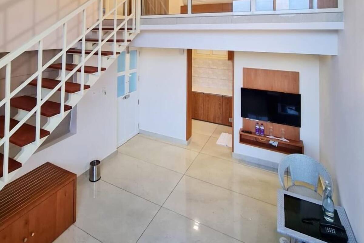 Eine moderne Wohnung mit Treppe, einem Wohnbereich mit Sofa und Tisch sowie einer Küchenzeile.