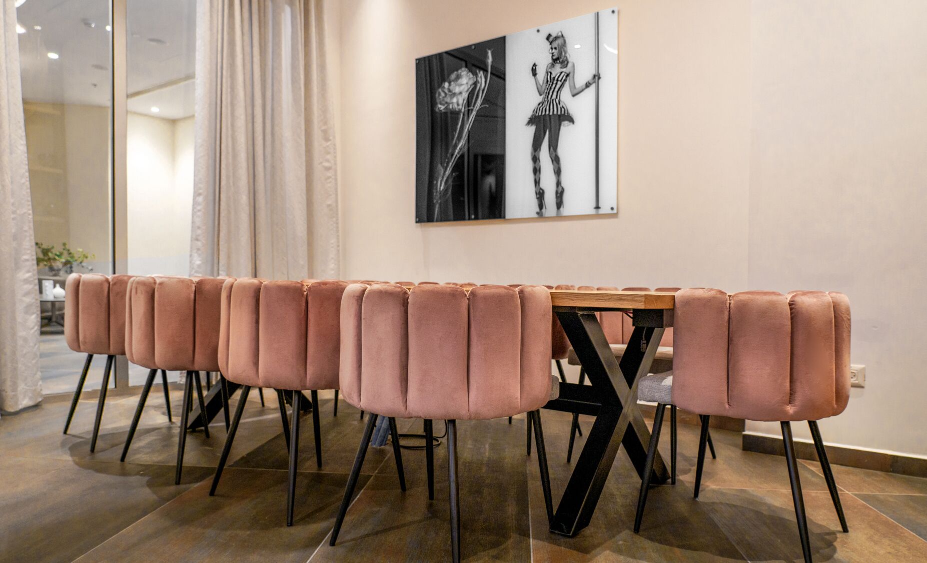 A modern dining area with a long table and matching pink upholstered chairs.