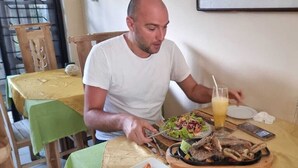 Une table à manger avec un repas, un verre de jus de fruits et un téléphone portable.