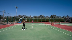 A tennis court with a net, green and red flooring, and a fence surrounding it. - SUNRISE Crystal Bay Resort - Posh Club (Hurghada)