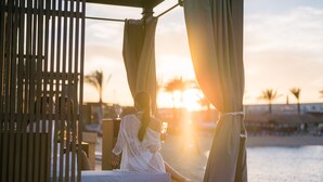 A couple relaxing on a sun lounger with a view of the sunset over the ocean. - SUNRISE Crystal Bay Resort - Posh Club (Hurghada)