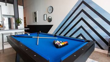 A pool table with a blue felt surface and a rack of billiard balls.