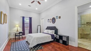Un dormitorio con cama, escritorio, silla y vestidor.